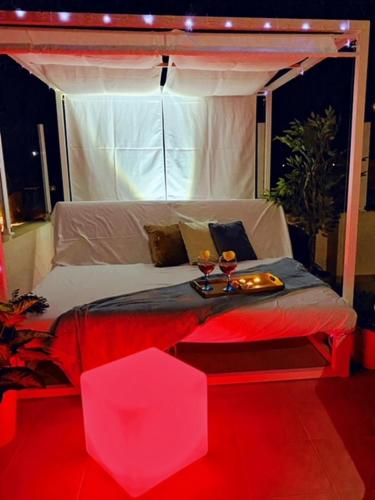 a bed with two glasses of wine on top of it at aptsmile sillot in S'Illot