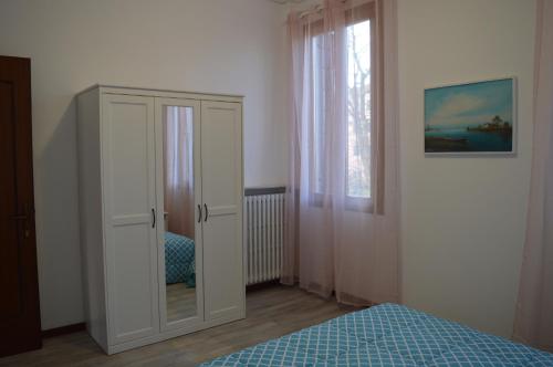a bedroom with a white cabinet and a bed at Noemi Venice Home in Marghera