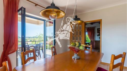 a dining room with a table with a bowl of fruit on it at Chalé Davim com piscina -Tranquilidade e conforto in Louriçal