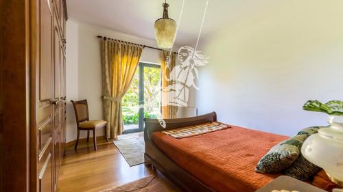 a bedroom with a bed and a chair and a window at Chalé Davim com piscina -Tranquilidade e conforto in Louriçal