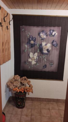 a painting of blue and white flowers on a wall at Alp House in Bohinjska Bela