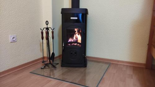 a black stove with a fire in the corner of a room at Alp House in Bohinjska Bela
