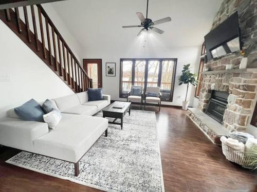 a living room with a white couch and a fireplace at Highland House: Lakefront, Hot Tub, Views, Private in East Stroudsburg