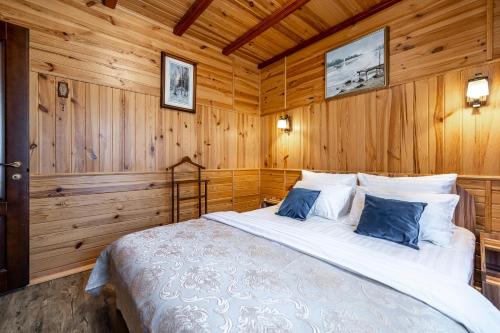 a bedroom with a large bed with wooden walls at Emerald House in Mykulychyn
