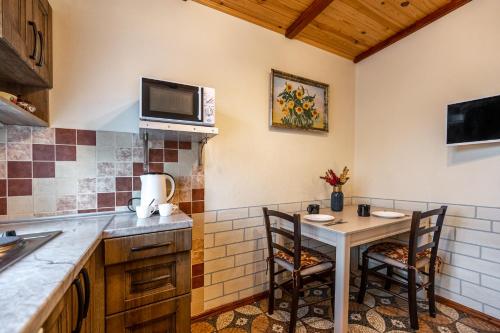 a kitchen with a table and chairs and a microwave at Emerald House in Mykulychyn