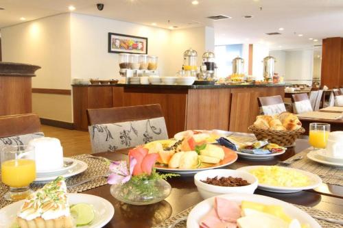 a table with plates of food on top of it at Suíte na região dos hospitais in Sao Paulo