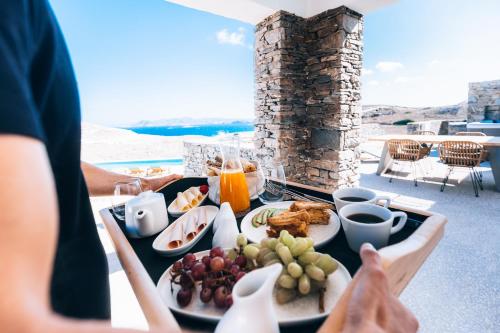 a table with a tray of food on a balcony at Ventus di Milo in Adamas