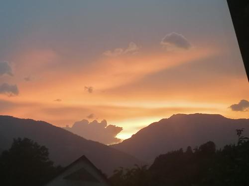 a sunset with mountains in the background at Apartments Novak in Ljubno