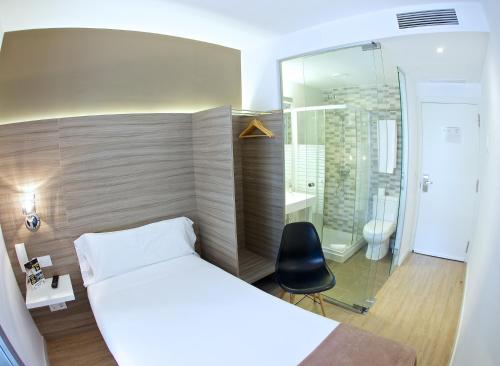 バルセロナにあるHotel BESTPRICE Diagonalのベッドルーム(白いベッド1台、黒い椅子付)
