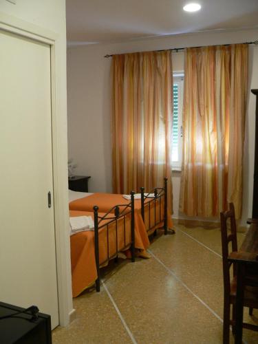 a bedroom with a bed and a window with curtains at Casamare Hotel in San Vincenzo