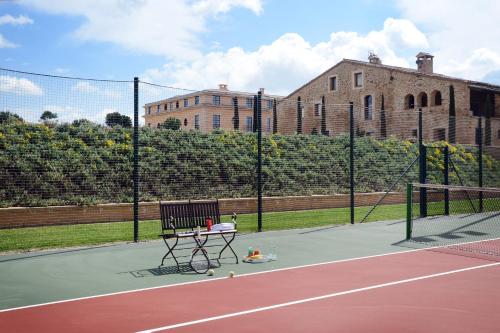 a tennis court with a bench on a tennis court at Casa Anamaria Hotel in Ollers