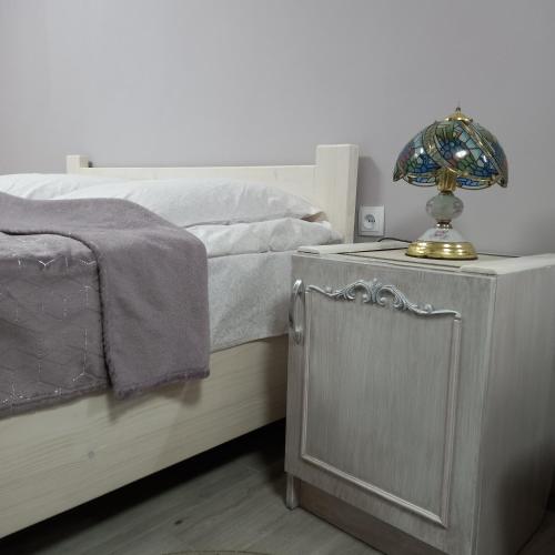 a bed with a table with a lamp on it at Три горішки in Yaremche