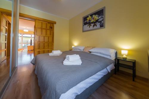 1 dormitorio con 1 cama grande y toallas. en Komfortowy Apartament w centrum Ustronia, en Ustroń