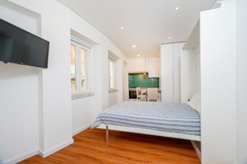1 dormitorio con 1 cama y TV de pantalla plana en 7ti7 Telhal apartment with a lovely Backyard, en Lisboa