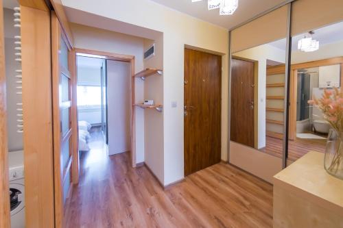 Pokój z przedpokojem z lustrami i drewnianą podłogą w obiekcie Komfortowy Apartament w centrum Ustronia w Ustroniu