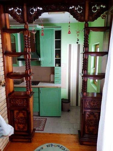 a green kitchen with green cabinets and a table at Kraljevi Konaci Olja in Zlatibor