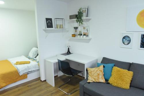 a living room with a desk and a couch at Central Apartment in Ćuprija