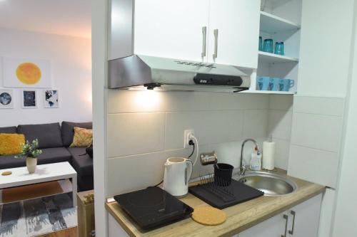 a small kitchen with a sink and a counter top at Central Apartment in Ćuprija