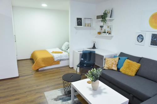 a living room with a couch and a bed at Central Apartment in Ćuprija