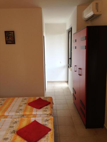 a bedroom with a bed and a dresser and a door at Zapovedni Rai in Primorsko