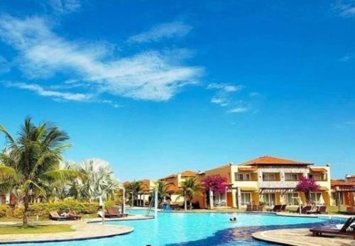 una piscina en un complejo con palmeras y casas en Búzios Beach Resort Residencial 1305, en Búzios