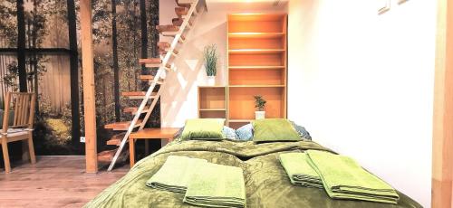 a bedroom with a bed with green sheets and a staircase at Buda Natura in Budapest