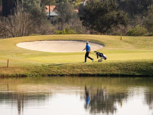 a man walking a dog on a golf course at Lagoa House - Casa típica Algarvia in Lagoa
