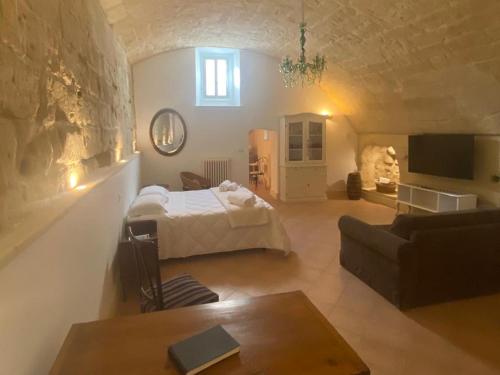 a living room with a bed and a couch at Le Case Nuove Room in Matera