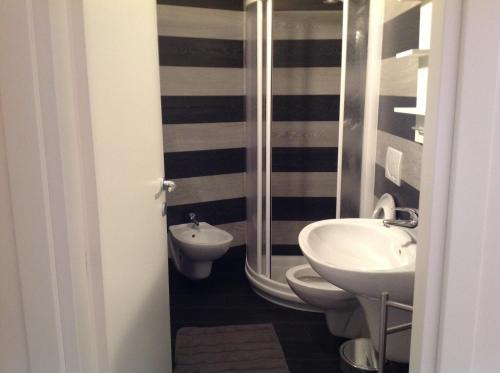 a black and white bathroom with a sink and a toilet at Appartamenti Villa Padania in Malcesine