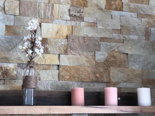 a vase with flowers in it on a table with candles at Snow peak Wellness & Spa, Kopaonik Milmari N5 in Kopaonik