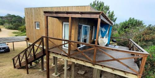 a tiny house on a deck with a porch at Marasaias in La Pedrera