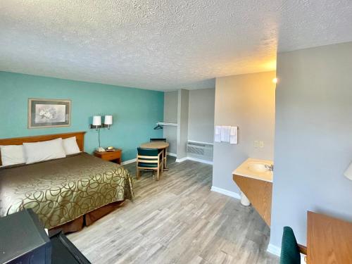 a hotel room with a bed and a desk at Overton Motel in Livingston