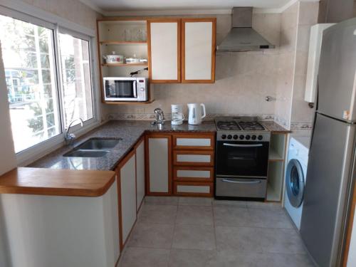 a small kitchen with a stove and a refrigerator at La Perla in Mar del Plata