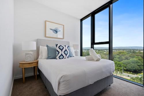 a bedroom with a large bed and a large window at The Gallery Broadbeach - GCLR in Gold Coast