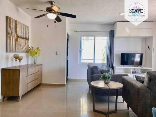 a living room with a couch and a ceiling fan at Lindo y Acogedor Departamento con todo lo necesario in Cancún