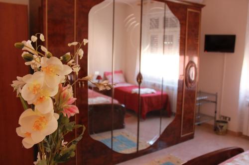 un vaso di fiori davanti a uno specchio di B&B Altea a Pescara
