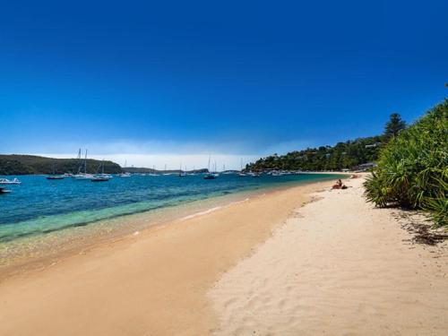 a sandy beach with boats in the water at The Lighthouse at Iluka Resort Apatments in Palm Beach