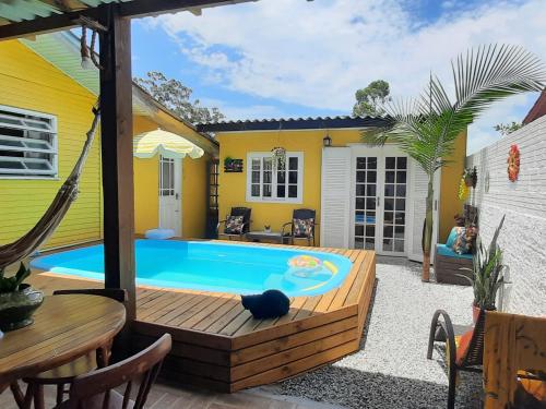 a backyard with a swimming pool and a house at Villacasamarela mini casinhas de hospedes Rio vermelho in Florianópolis