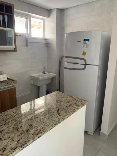 een keuken met een koelkast en een wastafel bij Makaiba Residence in Porto De Galinhas