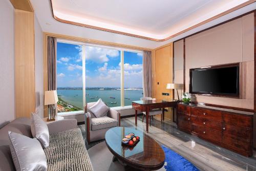 a living room with a television and a large window at Wyndham Grand Foshan Gaoming in Gaoming