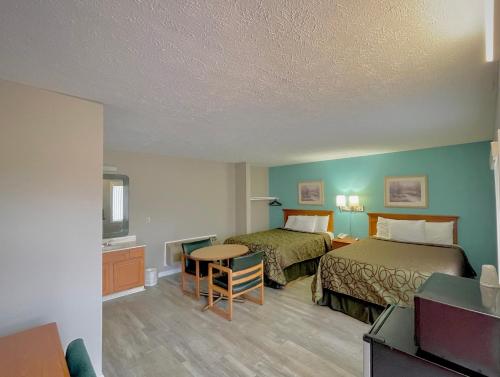 a hotel room with two beds and a table at Overton Motel in Livingston