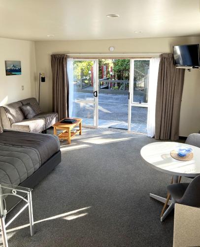 a living room with a couch and a table at Jade Court Motel in Hokitika