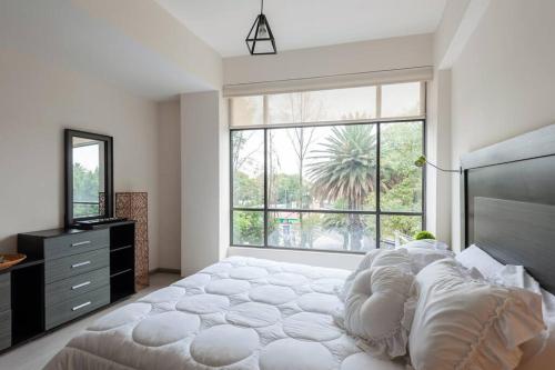a bedroom with a large bed and a large window at Mexico City MondoMexico Deluxe 2 Bedroom apartments in Mexico City