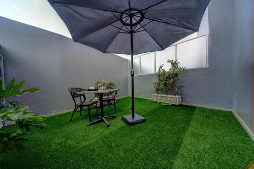 a patio with a table and an umbrella in a room at Golden Star Casablanca in Casablanca