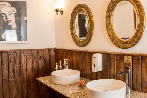 baño con 2 espejos y lavamanos en Hotel Inca Real, en Cuenca