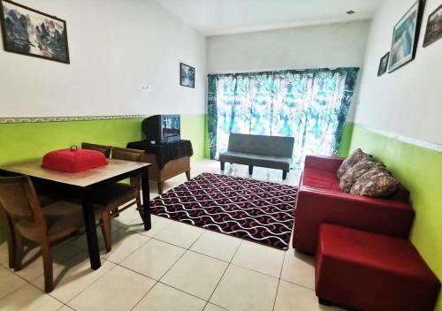 a living room with a red couch and a table at Homestay Cameron Highlands Mikayla in Cameron Highlands