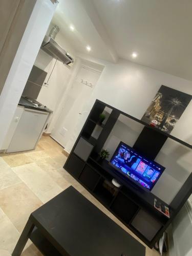 un salon avec une table noire et une télévision dans l'établissement Studio plein centre aix en Provence, à Aix-en-Provence