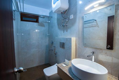 a bathroom with a sink and a toilet and a mirror at Hotel Shambhala in Gangtok