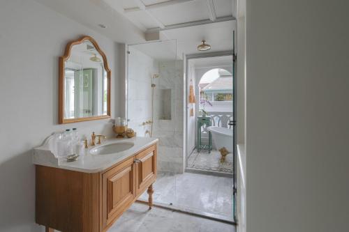 a bathroom with a sink and a mirror and a shower at The Inside House in Chiang Mai