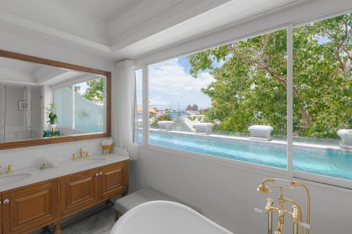 a bathroom with a tub and a sink and a window at The Inside House in Chiang Mai